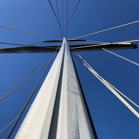 Looking up a sailing yacht's mast against the sky